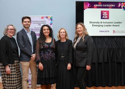 5 smiling people standing shoulder to shoulder