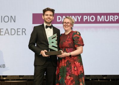 Two smiling people standing shoulder to shoulder on a stage