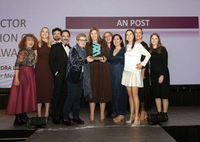 11 smiling people standing shoulder to shoulder on a stage