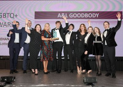 Ten smiling people standing shoulder to shoulder on a stage