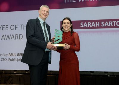 Two smiling people standing shoulder to shoulder on a stage
