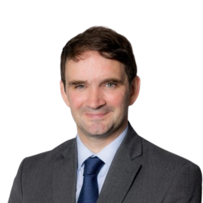 Head and shoulders shot of a smiling person wearing a grey suit with light blue shirt and navy blue tie